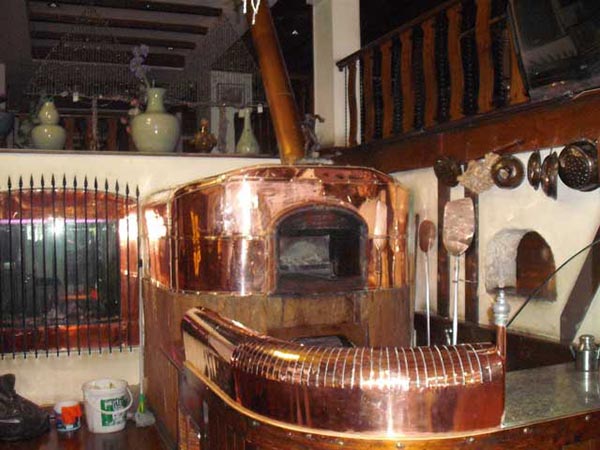 Pizza oven with copper decoration in a pizzeria in Pattaya