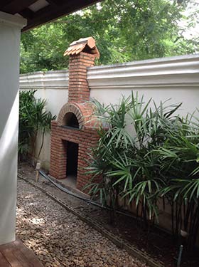 Classic red bricks Italian pizza oven in a garden